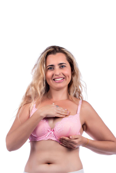 žena prsa self care a vyšetření na hrudky nebo podivné příznaky, s růžovou podprsenkou přes bílé pozadí. - Fotografie, Obrázek