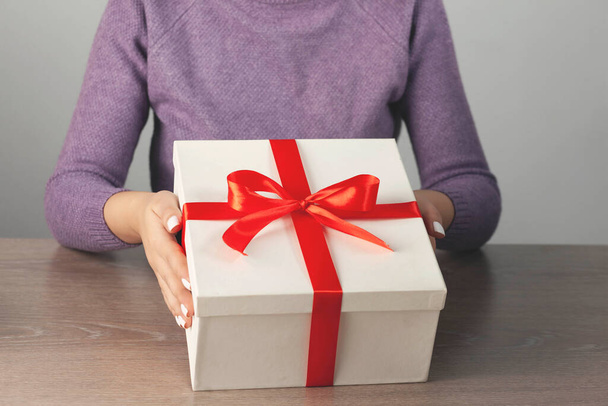 woman hand holding gift box on the desk - Photo, image