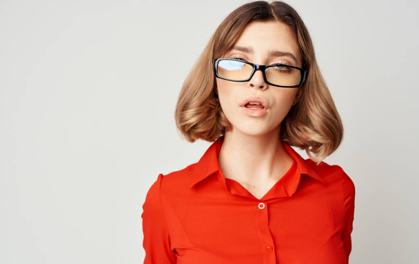 Mulher de negócios confiante em uma camisa vermelha e óculos emoções fundo bege - Foto, Imagem