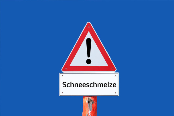 Precaución Melting Snow Warning Sign on Blue Background in German - Foto, imagen