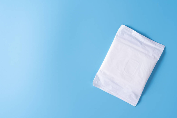 Sanitary pad, Sanitary napkin on blue background. Menstruation, Feminine hygiene, top view. - Photo, Image