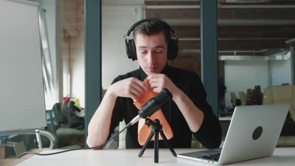 若い男ブロガーはオフィスでビデオブログを記録しながら、彼の鼻をくしゃみと吹く。病気の男性vloggerレコードビジネスビデオブログで彼の職場でオフィス. - 映像、動画