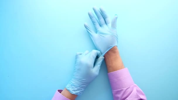mężczyzna lekarz nosi medyczne rękawiczki, zbliżenie - Materiał filmowy, wideo