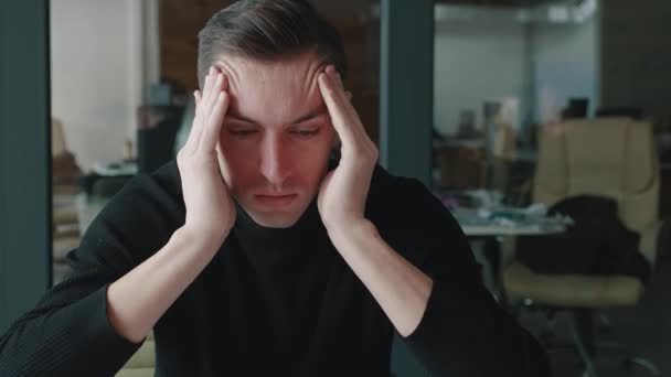 Stressed young man suffering from muscles tension, having painful head feelings due to overwork or sedentary working lifestyle. Tired depressed employee overwhelmed with tasks in office. - Footage, Video