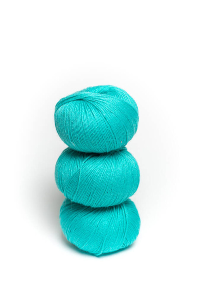 green skeins of wool yarn on a white insulated background. - Фото, изображение