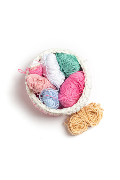 Remnants of yarn in a woven textile basket on an isolated background. Everything for manual work - Φωτογραφία, εικόνα