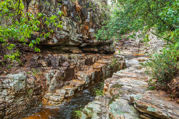 Kayaların yanından geçen bir nehir, Capitolio MG, Brezilya 'nın ekolojik turizm manzaralı tortulu kaya duvarı.. - Fotoğraf, Görsel