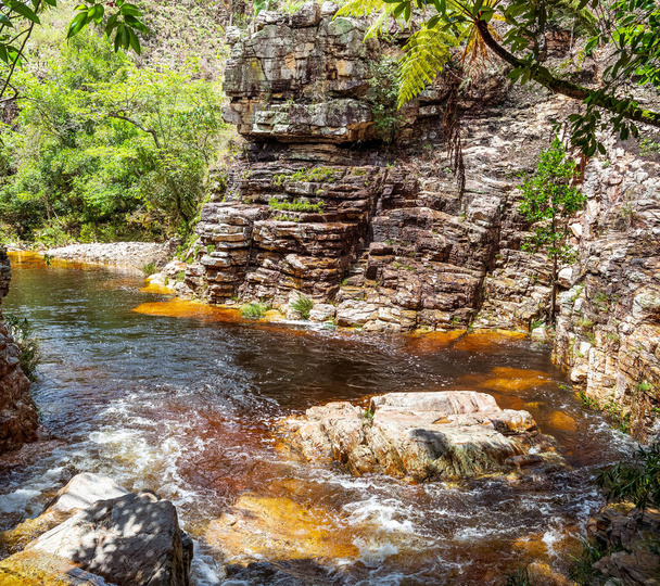 Ruscello d'acqua di un fiume che scorre vicino alle rocce sedimentarie, acqua dai toni arancio a causa delle rocce, paesaggio naturale di Capitolio MG, Brasile. - Foto, immagini