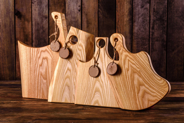 Σετ από όμορφες ξύλινες σανίδες κοπής σε ξύλινο τραπέζι. Μαγείρεμα στην κουζίνα - Φωτογραφία, εικόνα