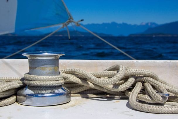 A rope wrapped around a sailboat winch for the jib sheet while sailing in British-Columbia, Canada, in the Georgia Straight on a windy day - Fotoğraf, Görsel