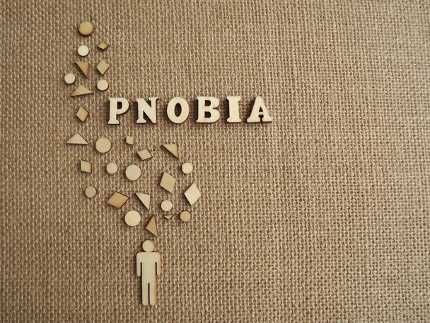 психическое заболевание-фобия в виде деревянных букв и фигур людей на джутовом фоне - Фото, изображение
