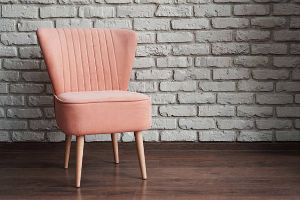 Pink chair on a white brick wall background - 写真・画像