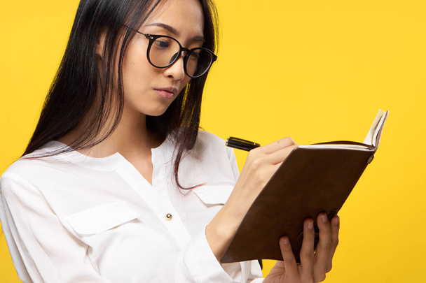csinos nő egy notebook a kezében ír a sárga háttér - Fotó, kép