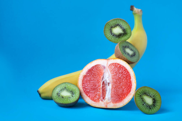 Свіжі тропічні фрукти. Різні фрукти лежать на синьому фоні. Корисні вітаміни
 - Фото, зображення