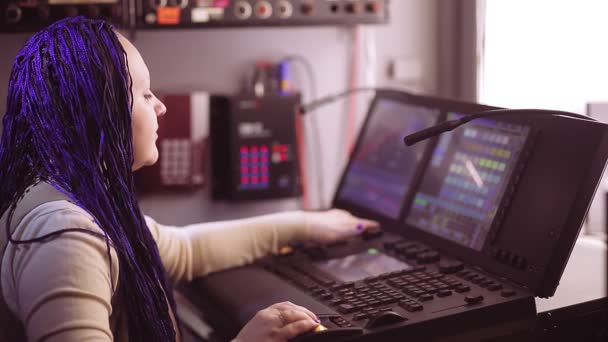 Obrazowa redaktorka Kobieta z niebieskimi afrokos na konsoli Grand ma pracuje z programowaniem oświetlenia. - Materiał filmowy, wideo