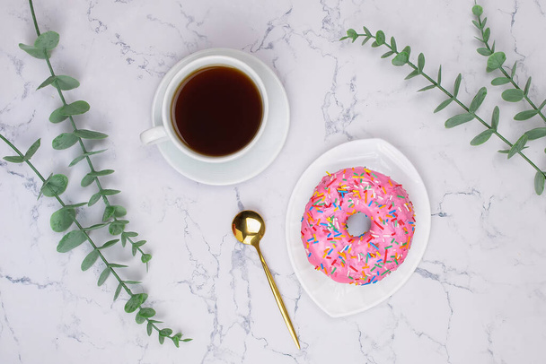 Cup of black coffee with pink donut on the white marble background - Fotografie, Obrázek