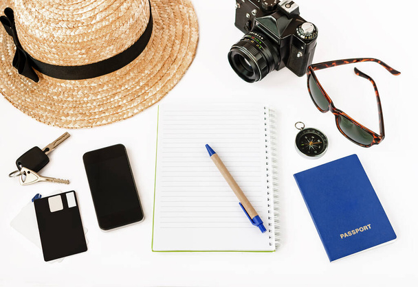 top view of notepad with pen, phone, camera, sunglasses on white background - Photo, Image