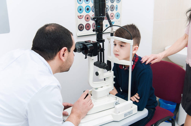 Niño con mamá en examen ocular por oftalmólogo - Foto, Imagen