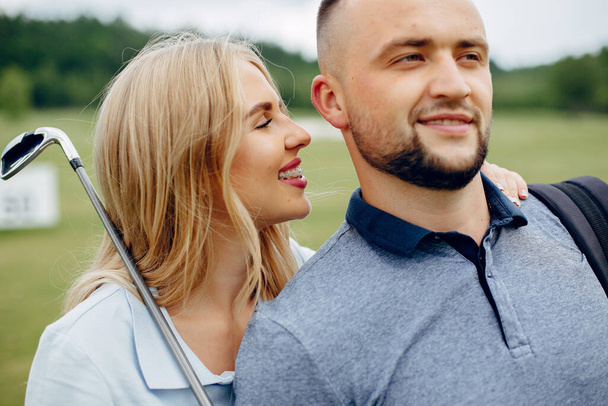 Beautiful couple playing golf on a golf course - Foto, Bild