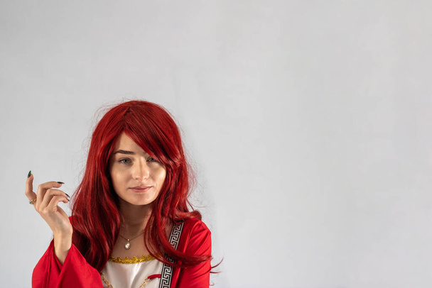 Teljes hossz fiatal nő vonzó modell egy stúdióban, fehér háttér, a modell visel egy piros középkori jelmez vörös aranybarna haj - Fotó, kép