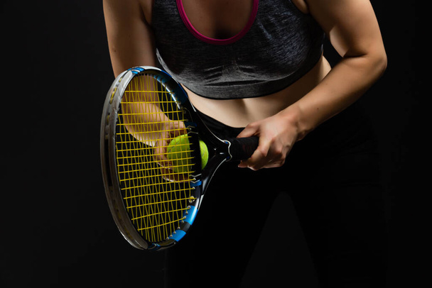 Jovem jogadora de tênis posando com raquete em fundo preto - Foto, Imagem