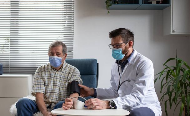 Лікар консультує літнього пацієнта чоловічої статі вдома
 - Фото, зображення