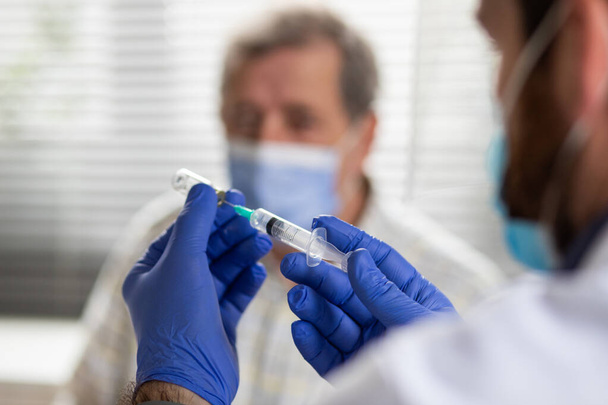пожилой человек получает коронавирусную вакцину - Фото, изображение