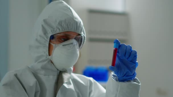 Βιοχημικός σε coverall εκμετάλλευση δείγματος αίματος ανάλυση χημικής αντίδρασης - Πλάνα, βίντεο