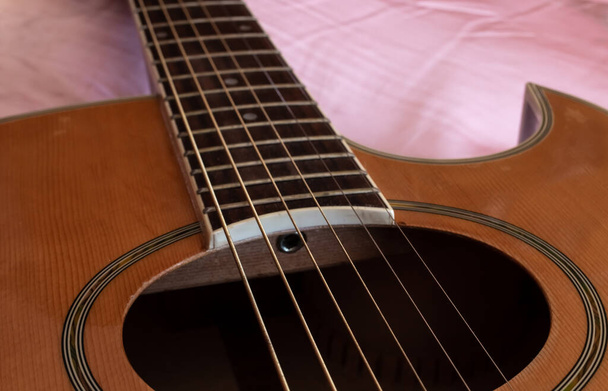 Primer plano del agujero de sonido de una guitarra eléctrico-acústica, con cuerdas gruesas y un tablero de traste de esmalte, Londres, Ontario, Canadá.  - Foto, Imagen