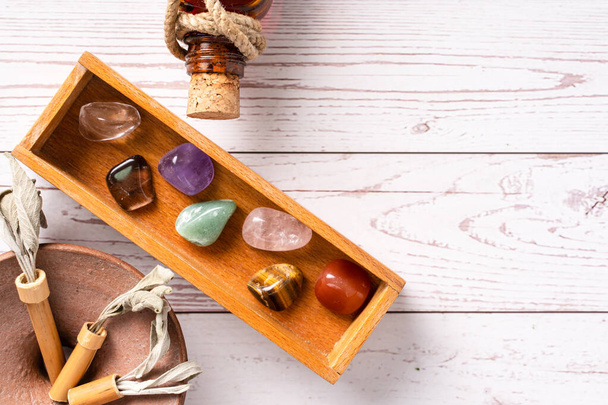 Top down view on seven chakra healing crystal stones for mind body and soul reiki practicing homeopathy alternative medicine on wooden table with copy space - Valokuva, kuva