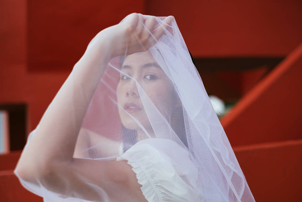 De cerca - Retrato de hipster joven asiático largo pelo oscuro mujer novia con velo blanco. - Foto, Imagen