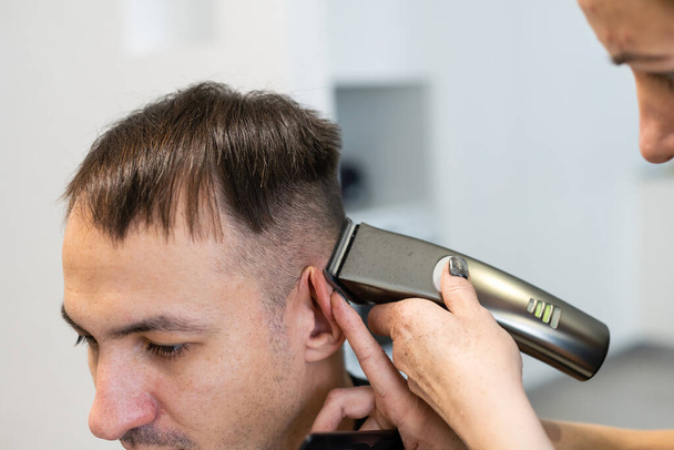 Uomo ottenere un taglio di capelli da un parrucchiere. - Foto, immagini