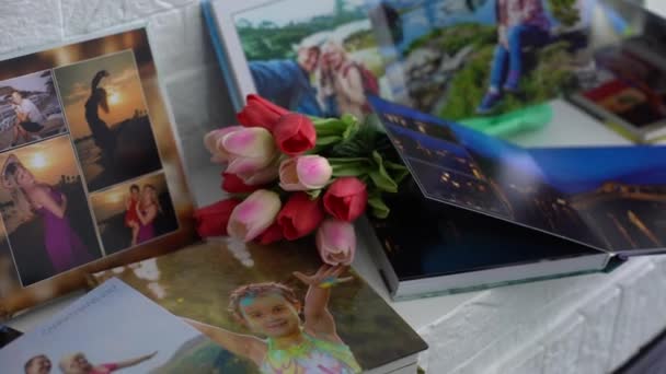 fotoboek en bloemen tulpen als vakantiecadeau liggen op de plank - Video