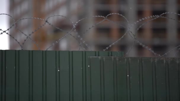 De grands murs de prison avec des barbelés, des fils de clôture éloignés et la tour de garde sont apparents à distance - Séquence, vidéo