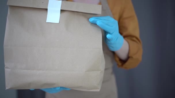 gezondheidsbescherming, veiligheid en pandemie concept - levering vrouw in het gezicht beschermende masker en handschoenen met pakket doos en over magazijn achtergrond - Video