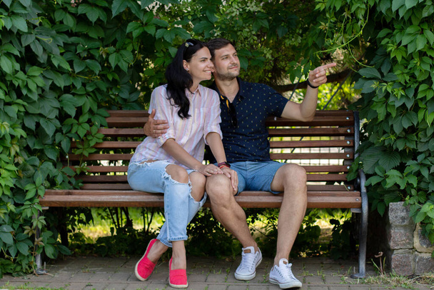 guy with a girl sitting on a bench in the park in summer - Foto, afbeelding