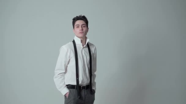 Ein junger Mann in weißem Hemd auf weißem Hintergrund zeigt verschiedene Emotionen im Gesicht. Er wendet sich der Kamera zu, als wolle er etwas andeuten. Leerer Raum zum Einfügen. - Filmmaterial, Video