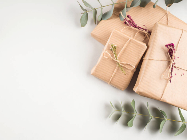 Cadeau doos verpakt in ambachtelijk papier met gedroogde bloemen - Foto, afbeelding