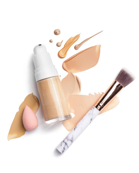 Bottle of makeup foundation, brush, sponge and samples on white background - Photo, Image
