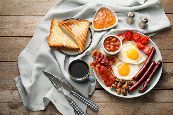 Traditional English breakfast with fried eggs on wooden background - Photo, Image