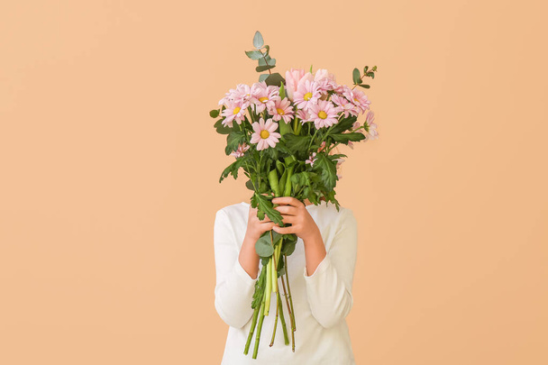 Cute little girl with bouquet of beautiful flowers on color background - 写真・画像