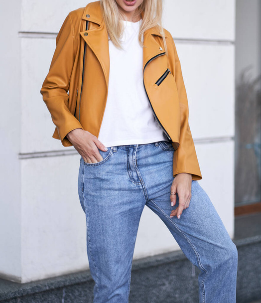 Woman wears yellow jacket during fall season. Beautiful blonde girl standing in the casual style street wear. Successful woman template - Photo, Image