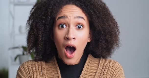 Nahaufnahme schockiertes weibliches Gesicht, überraschte Reaktion, afroamerikanische lockige Mädchen hörte erstaunliche unerwartete Nachricht öffnet ihren Mund vor Stressangst enthusiastisch hält Kopf mit Händen, Überraschungskonzept - Filmmaterial, Video