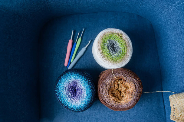 Kuličky barevné příze pro ruční pletení na dluhovém pozadí. Jehly a řemeslná koncepce. Horní pohled - Fotografie, Obrázek