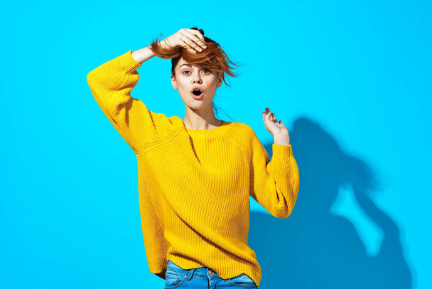 attractive woman in yellow sweater and jeans casual wear emotions posing blue background - Foto, immagini