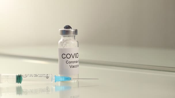 Tuba ze szczepionką przeciw koronawirusowi dla wirusa COVID-19 2019-nCoV ze strzykawką - Materiał filmowy, wideo