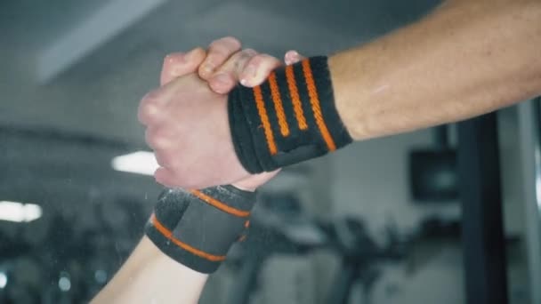 Twee gespierde mannen schudden elkaar de hand in de sportschool - Video