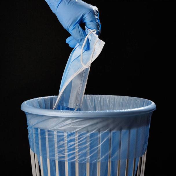 Απορρίψτε την ασπίδα προσώπου coronavirus στα σκουπίδια μετά τη χρήση. Μην ρυπαίνετε το περιβάλλον..  - Φωτογραφία, εικόνα