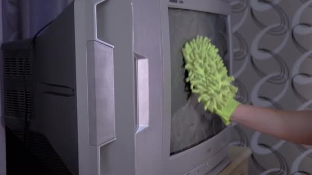 Mano femenina en guantes anaranjados Pantalla de TV vieja con un trapo de microfibra verde - Imágenes, Vídeo