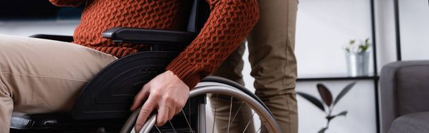 vue recadrée du fils près du père handicapé en fauteuil roulant, bannière - Photo, image